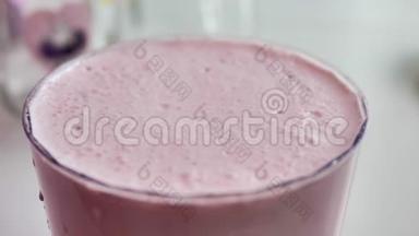 透明玻璃中的粉红色奶昔，<strong>气泡破裂</strong>，特写，自然光